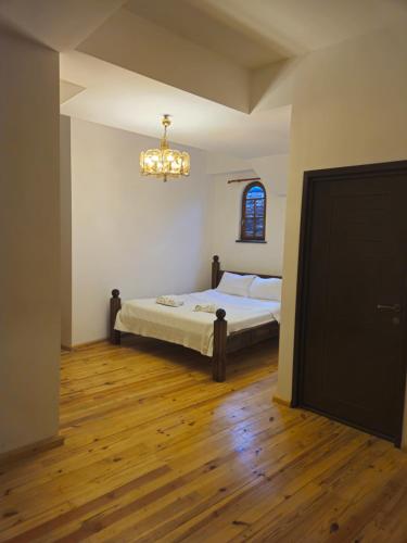 a bedroom with a bed and a chandelier at Boutique Hotel Verdzi in Kutaisi