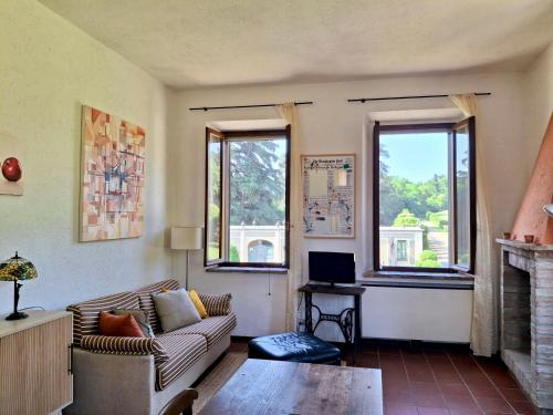 ein Wohnzimmer mit Couch und Kamin in der Unterkunft La finestra sul parco Croara Country Club in Pieve Dugliara