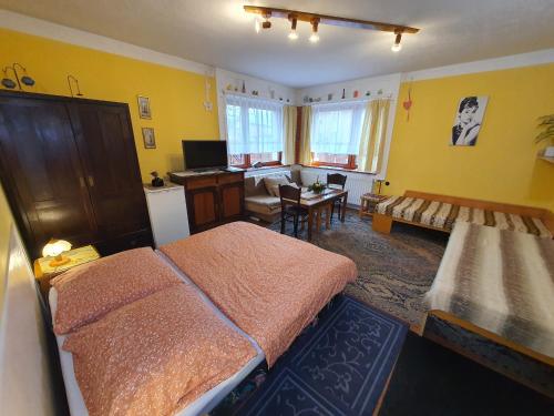 a bedroom with two beds and a living room at Privat Henry in Liptovský Mikuláš