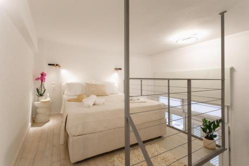 a white bedroom with a bed and a glass wall at Agnes Loft at Campiello in Corfu