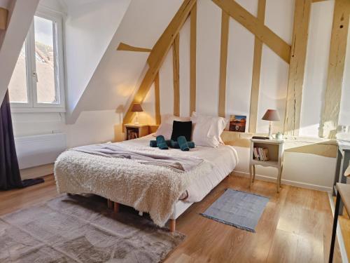 a bedroom with a bed with two teddy bears on it at Les Suites Marcel Proust in Illiers