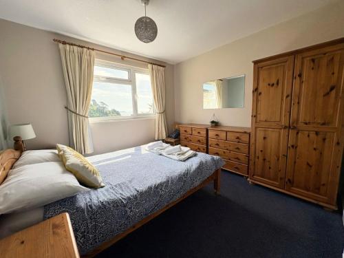 a bedroom with a bed and a window and a dresser at Sunrise Bay - Mount Brioni in Downderry