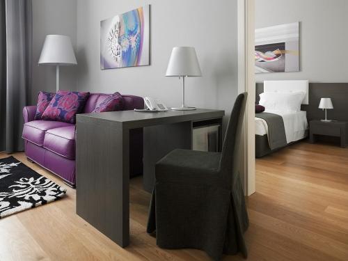 a living room with a purple couch and a desk at Palace Suite in Trieste