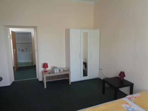 a room with a bed and a table and a mirror at Hotel U Lázní - ubytování pro nenáročné in Ostrožská Nová Ves