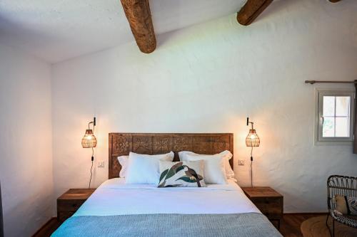a bedroom with a bed with white sheets and two lamps at LES TERRASSES DE LORGUES - B&B de charme en Provence in Lorgues