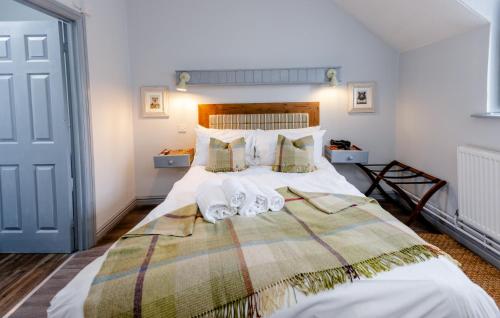 a bedroom with a large bed with towels on it at The White Horse Inn in Deddington