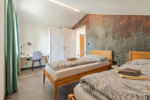 Un dormitorio con dos camas y un escritorio. en Holiday Home Lukc with free parking, en Kobarid