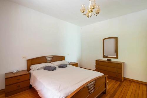 a bedroom with a bed and a mirror and a chandelier at As Neveiras in Millerada