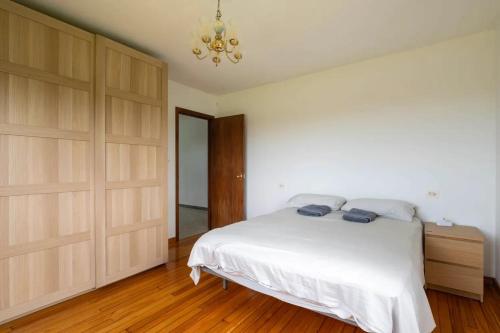 a bedroom with a white bed and wooden cabinets at As Neveiras in Millerada