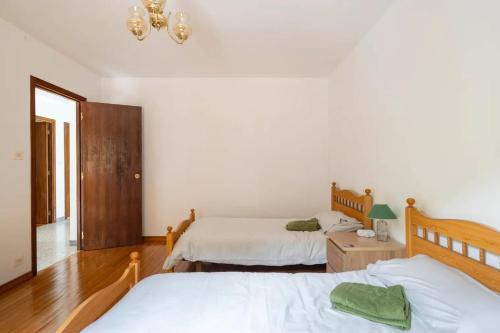 a bedroom with two beds and a chandelier at As Neveiras in Millerada