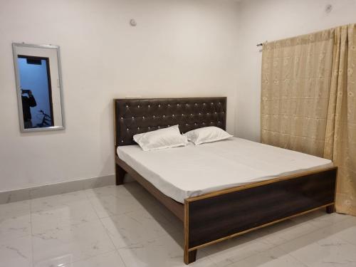 a bed sitting in a room with a mirror at Shree Shyam Paying Guest house in Varanasi