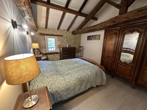 a bedroom with a bed with a lamp and a dresser at Paloumat in Larbey