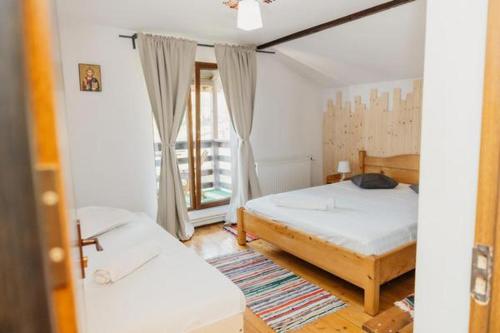 a bedroom with two beds and a window at Casa BOBO in Baia de Fier