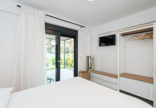 a bedroom with a white bed and a sliding glass door at Diamond D2 Iraklitsa in Iraklitsa