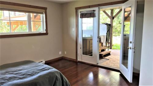a bedroom with a bed and a sliding glass door at L'Audacieux - SPA, Billard, Poker, Arcade, fleuve, l'évasion VIP in Petite-Rivière-Saint-François