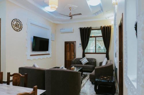 a living room with two couches and a tv at Sunny Palms Beach Bungalows in Uroa