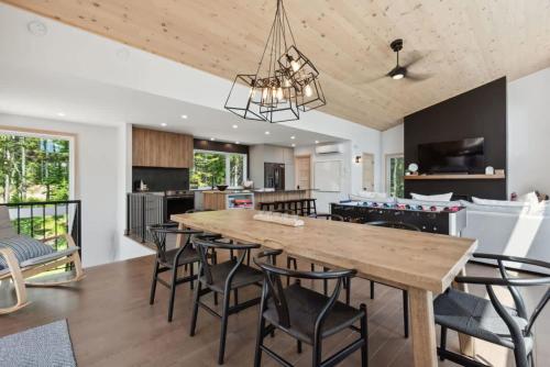 a kitchen and dining room with a large wooden table and chairs at Le Davinci - SPA and mountain in Petite-Rivière-Saint-François
