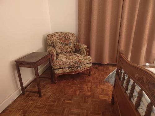 - une chambre avec une chaise et une table à côté d'un lit dans l'établissement Villa B, à Bobigny