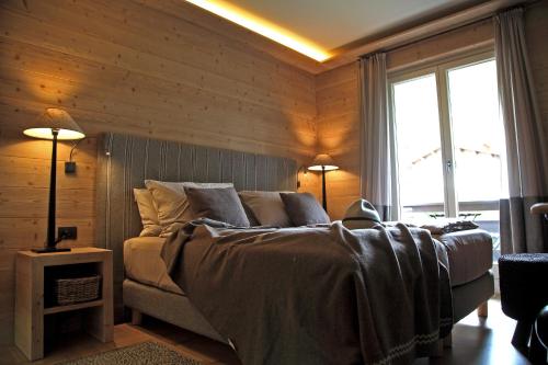 a bedroom with a bed in a room with wooden walls at La Genzianella Bormio in Bormio