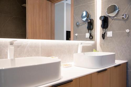 a bathroom with two sinks and a mirror at Unicos City Suites in Kos Town