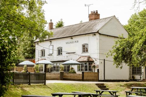 a white building with umbrellas in front of it at The Bell Inn, Ladbroke in Ladbroke