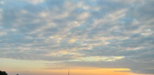 a kite flying under a cloudy sky at sunset at SAABY HoMESTAY in Kurseong