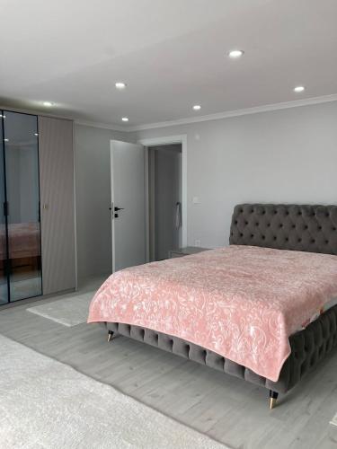 a bedroom with a large bed with a pink bedspread at Trabzon rize in Of