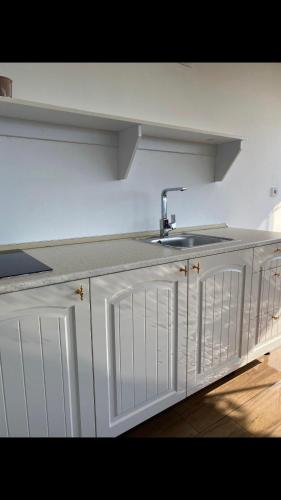 a kitchen with a sink and white cabinets at Trabzon rize in Of