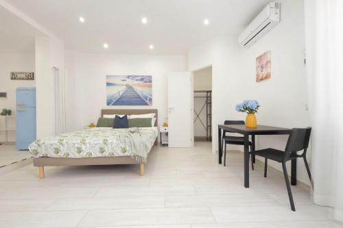 a bedroom with a bed and a table at Attico con balcone - Mare e Comfort in Lido di Ostia