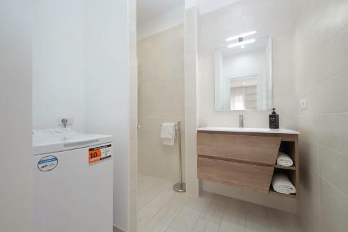 a white bathroom with a sink and a mirror at Attico con balcone - Mare e Comfort in Lido di Ostia