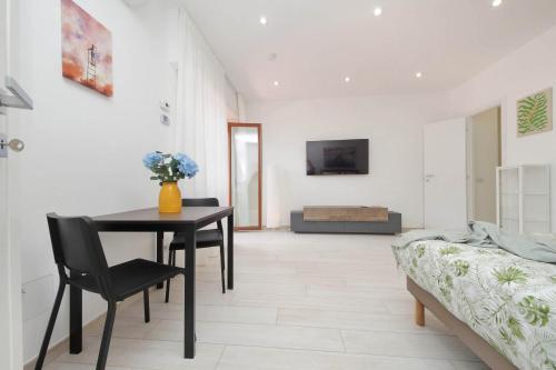 a living room with a table and a bed at Attico con balcone - Mare e Comfort in Lido di Ostia