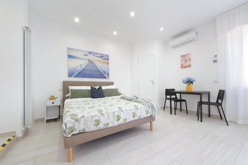 a bedroom with a bed and a table with chairs at Attico con balcone - Mare e Comfort in Lido di Ostia