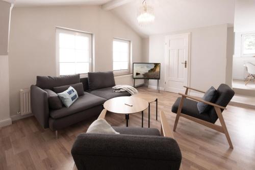 ein Wohnzimmer mit einer Couch und einem Tisch in der Unterkunft Villa Granitz Wind & Wolke in Ostseebad Sellin