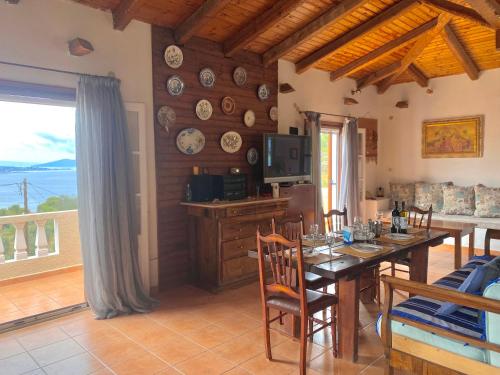 Un comedor con una mesa y un televisor. en Villa Brachera, en Spetses
