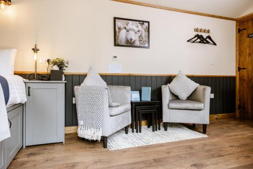 a bedroom with a bed and two chairs and a table at The Bell Inn, Ladbroke in Ladbroke