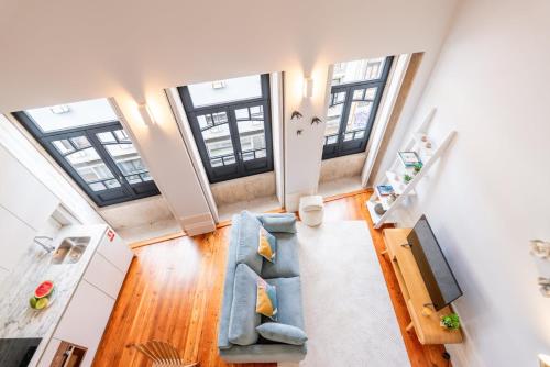 einen Blick über ein Wohnzimmer mit einem blauen Sofa in der Unterkunft Framed Corner by Portugal Active in Porto