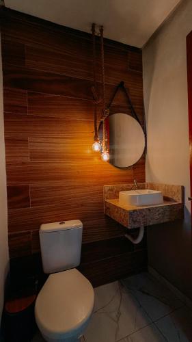 a bathroom with a white toilet and a sink at Lençóis Maranhenses - Casa Armonia in Santo Amaro