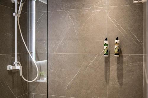 a bathroom with a shower with two shampoo bottles at Unicos City Suites in Kos Town