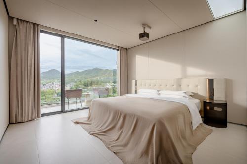 a bedroom with a large bed and a large window at private soup holiday villa by the sea in Dapeng