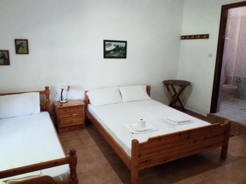 a bedroom with two beds and a table and a mirror at Athanasios Stafylas in Samothráki