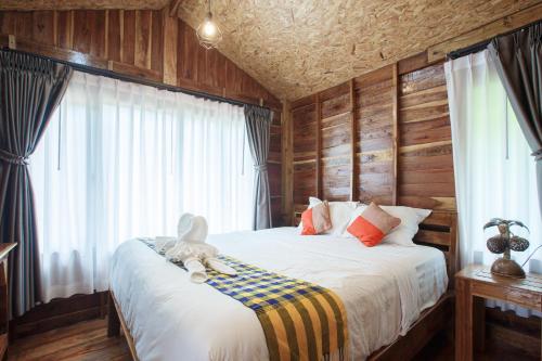 a bedroom with a bed with a teddy bear on it at บ้านสวนแก้วคำแพง Baan Suan Kaew Khampaeng in Udon Thani