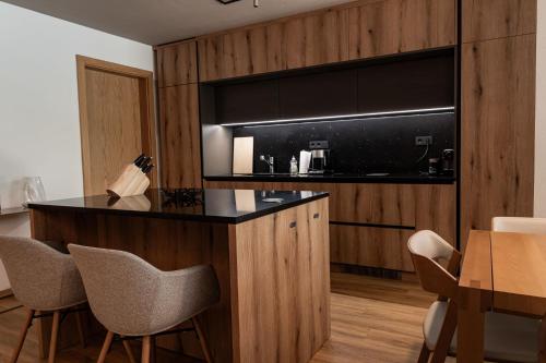 a kitchen with a counter and chairs in a room at Max Relax SUMMERCARD INCLUDED Ski in-ski out in Zell am See