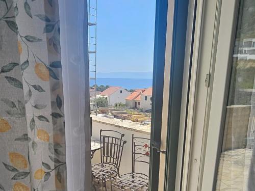 a window with a view of a balcony with a table and chairs at Rooms Anđelka in Bol