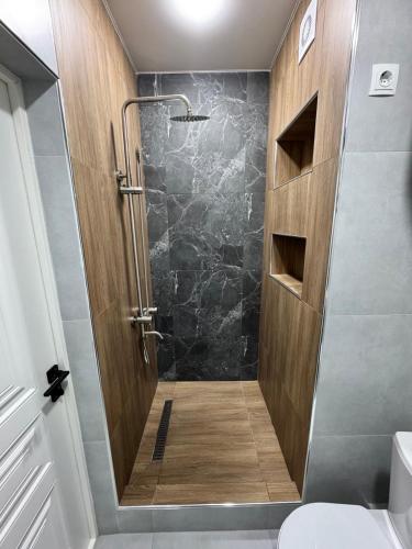 a shower with a glass door in a bathroom at Tower Apartments in Osh