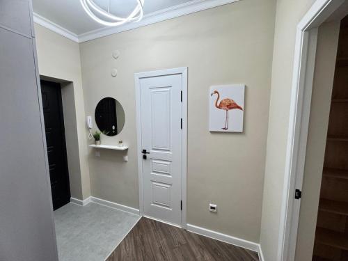 a hallway with a pink flamingo painting on the wall at Tower Apartments in Osh