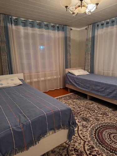 une chambre avec deux lits et un lustre dans l'établissement Guest House Baiel, à Bokonbayevo
