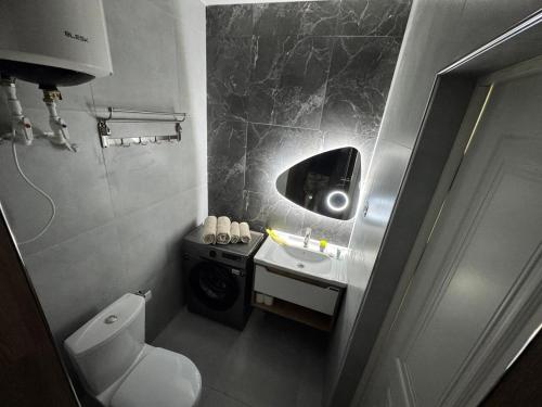 a small bathroom with a toilet and a sink at Tower Apartments in Osh