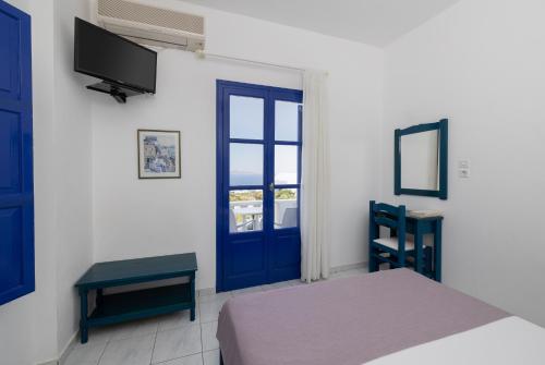 a bedroom with a bed and a blue door at Villa Happening in Imerovigli