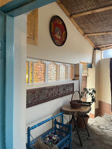 a room with a table and a clock on the wall at Guest House Ruh Achari in Sheki
