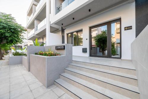 a facade of a building with stairs and flowers at Unicos City Suites in Kos Town